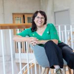 Eine junge Frau sitzt bequem in einem Sessel in einer modernen Location