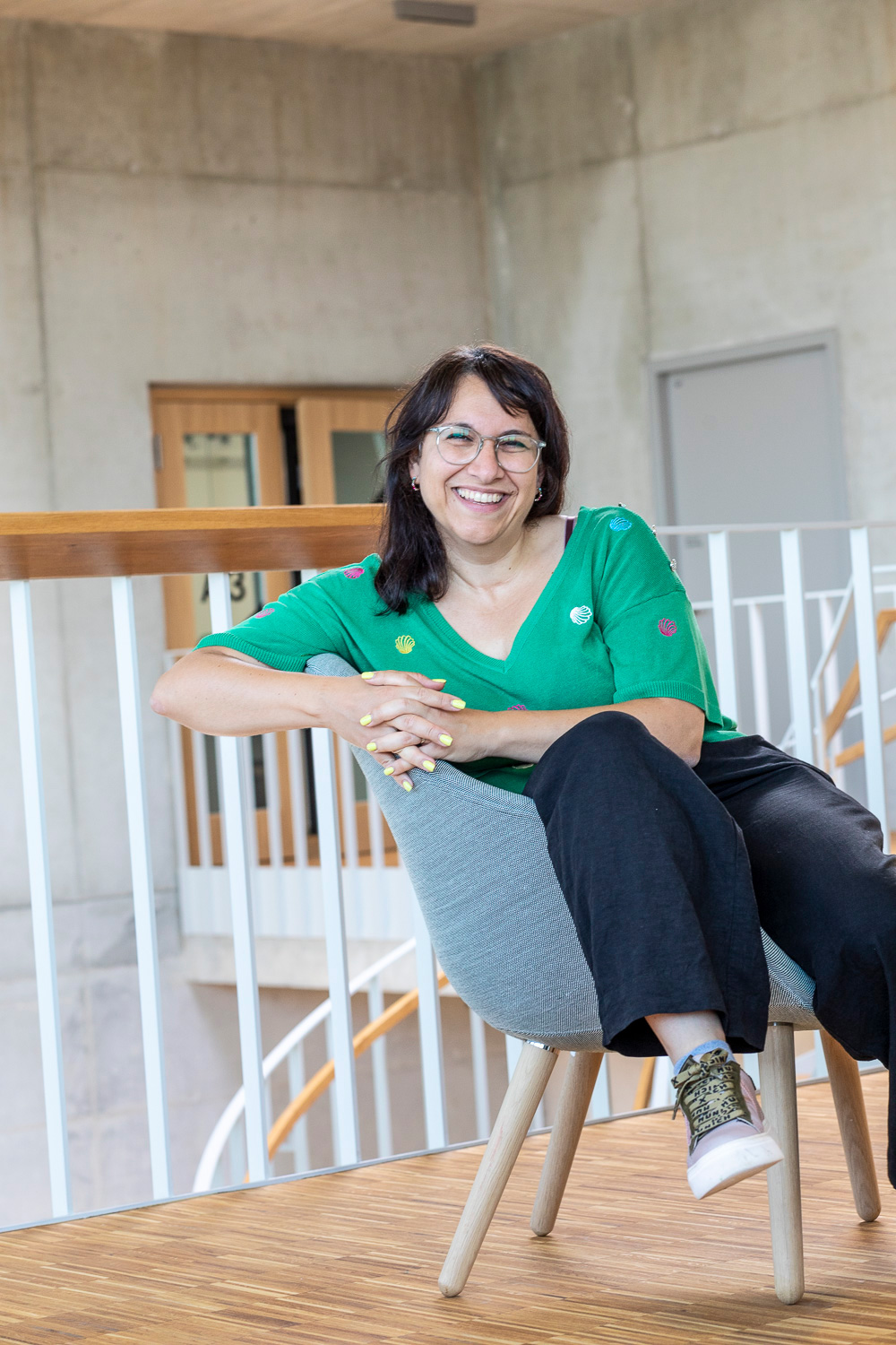 Eine junge Frau sitzt bequem in einem Sessel in einer modernen Location