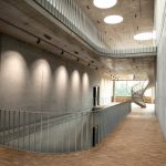 Gang in einem großen Gebäude, die Wände sind roh Beton, der Boden Parkett am Ende des Ganges sieht man eine Wendeltreppe