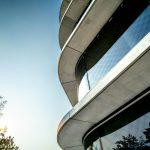 Ausschnitt einer Außenfassade mit großen runden Fenstern, die Etagen trennen sich durch Betonebenen die heraus stehen.