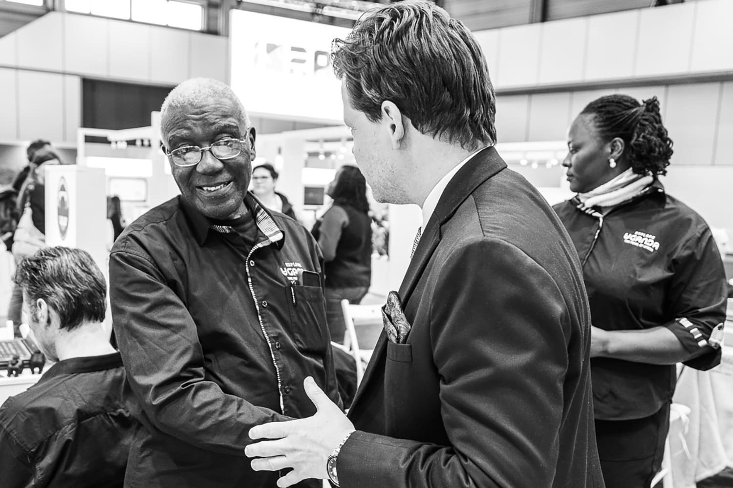 Zwei Menschen schütteln sich die Hand auf einer Messe