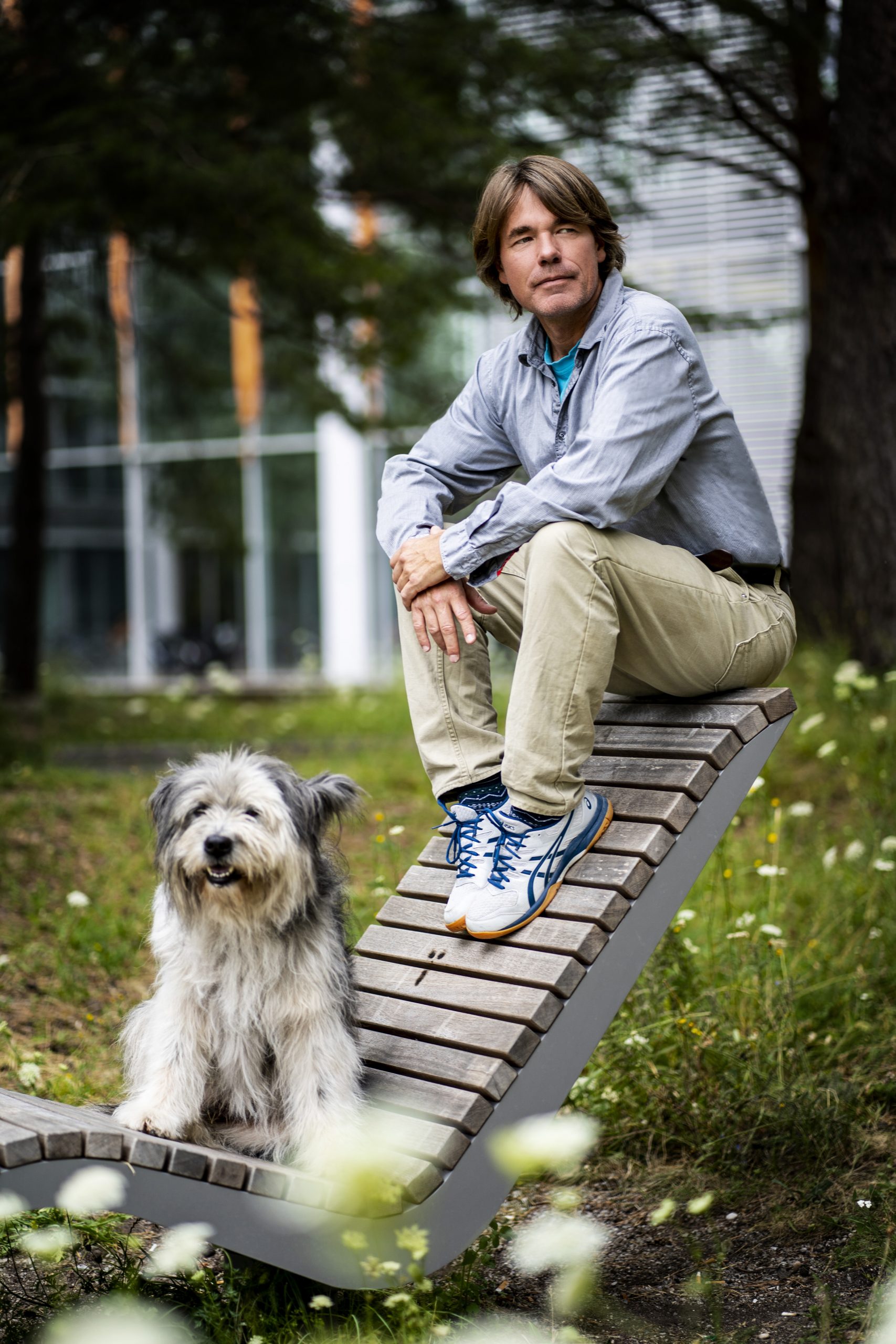 Bild von Matthias Tunger und Balou auf einer Bank im Freien mit urbanem Hintergrund