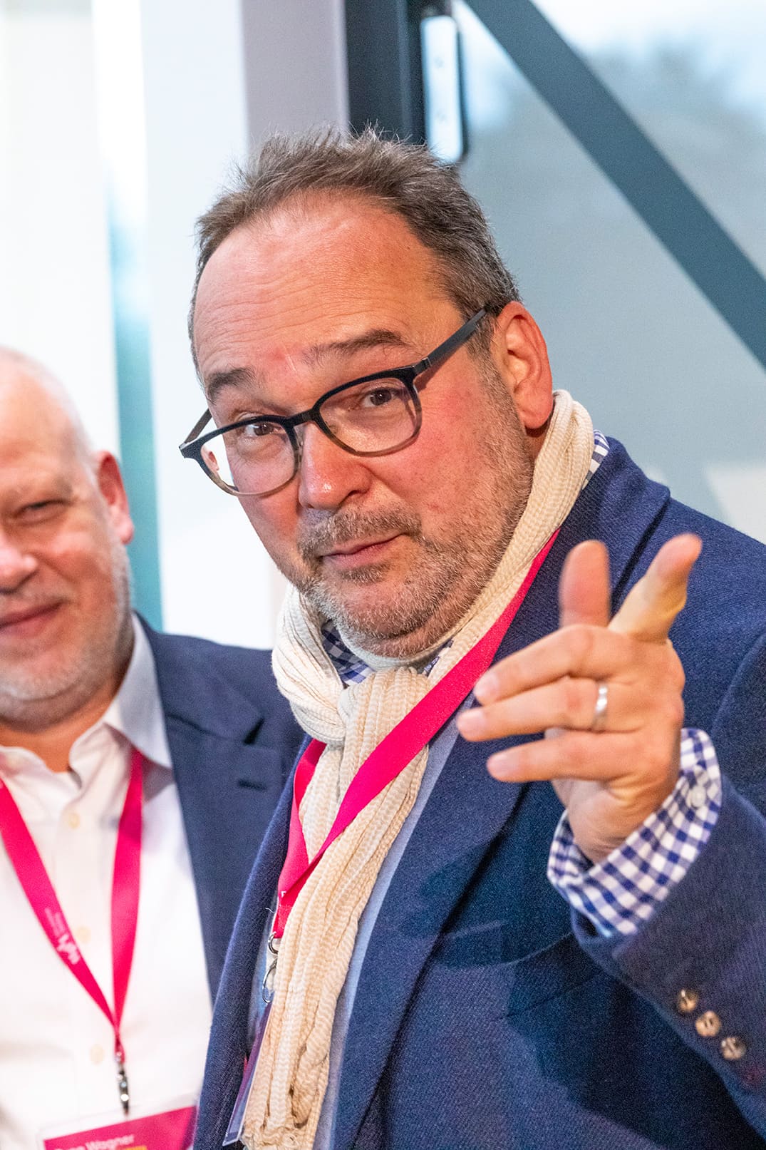 Ein Mann mit Brille zeigt mit dem Finger nach vorne