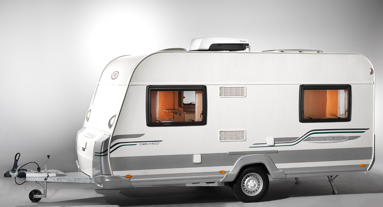 Ein klassischer Wohnwagen mit einer Truma Klima Anlage auf dem Dach fotografiert in einem Studio