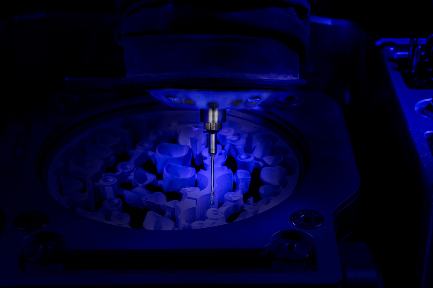 Close Up eines Fräskopfes einer Maschine für Zahnmedizin, Das asugefräste Teil ist blau eingefärbt, man sieht den Fräskopf